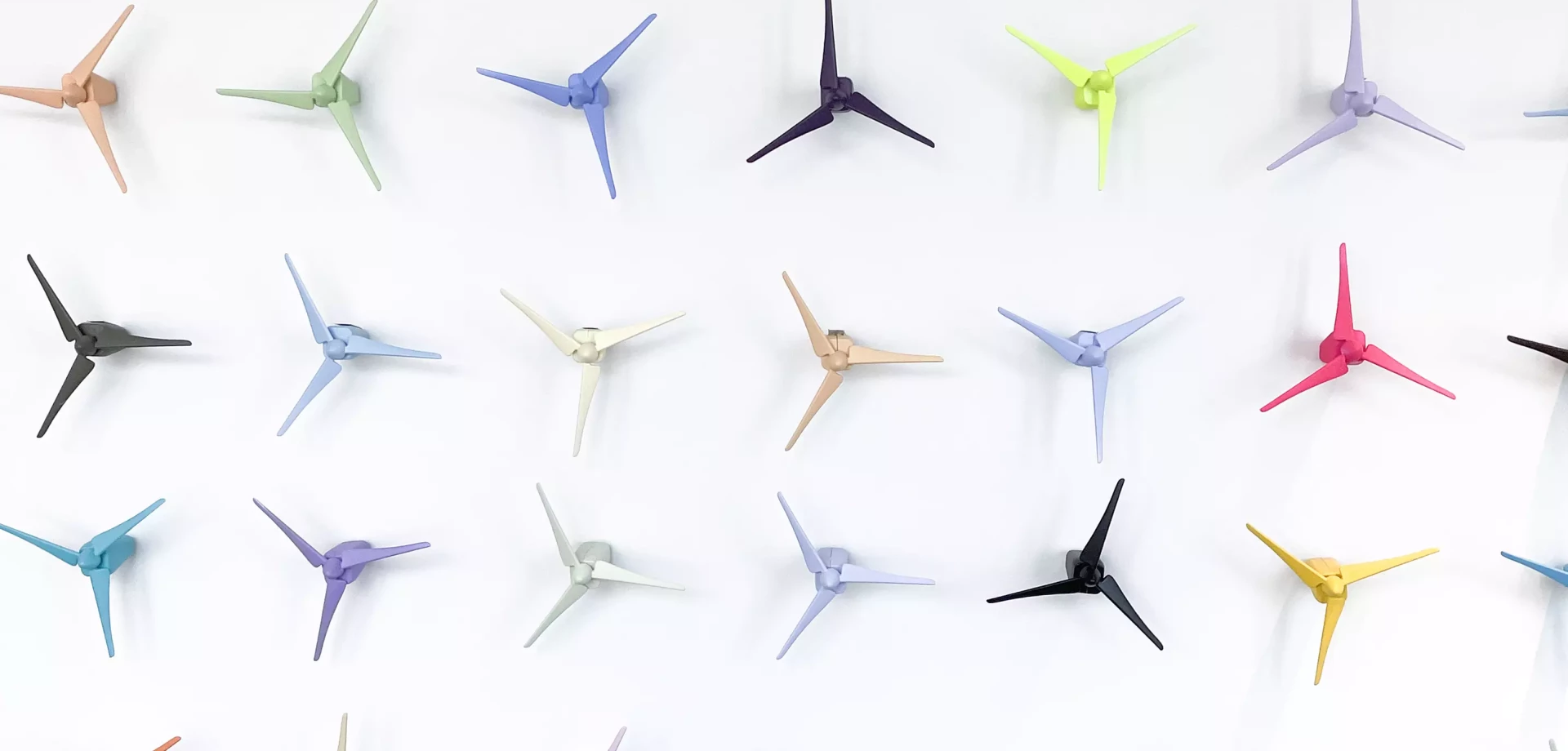 petites éoliennes de couleur contre un mur blanc